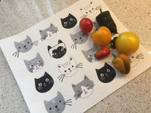 Load image into Gallery viewer, White cat-themed dish rack mat, featuring white, black, and grey cats. on a white kitchen surface. there are some vegetables laying on the towel